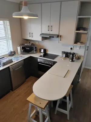a kitchen with a white counter top and a table at Leafy Retreat Kenridge in Durbanville