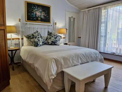 a bedroom with a large white bed and a window at Old Oak Guest House in Bellville
