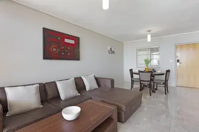 a living room with a couch and a table at Lagoon Beach 302A in Cape Town