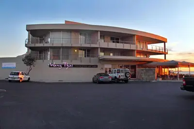 a large building with cars parked in a parking lot at Lagoon Beach 302A in Cape Town