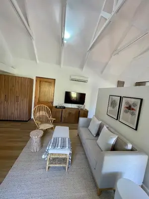 a living room with a couch and a table at Mountain Cottages at Haskell Vineyard in Stellenbosch