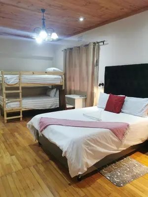 a bedroom with a bed and a bunk bed at Sunrise Lodge in Cape Town