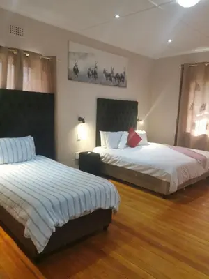 two beds in a hotel room with two beds at Sunrise Lodge in Cape Town