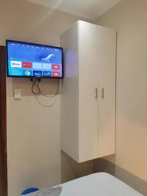 a white cabinet with a television on top of it at Sunrise Lodge in Cape Town