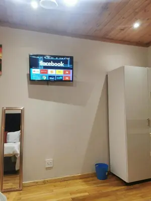 a television hanging on a wall in a room at Sunrise Lodge in Cape Town
