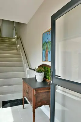 aoyer with a staircase and a table with a plant on it at The Whale and Waddler - Unit with a view in Kleinmond