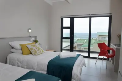 a bedroom with a bed and a view of the ocean at The Whale and Waddler - Unit with a view in Kleinmond