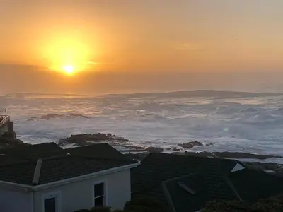 a view of the sun setting over the clouds at Whale Rock Estate Hermanus sea view apartment in Hermanus