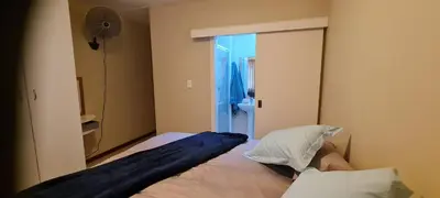 a bedroom with a bed with a pillow and a mirror at SEASCAPE MEWS 27 in Cape Town