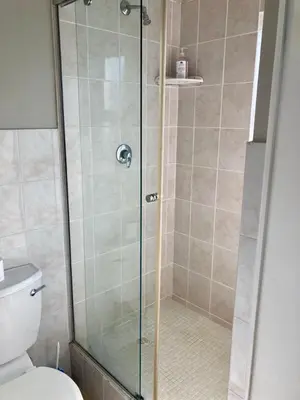 a shower with a glass door in a bathroom at 31 Tobago Bay in Hermanus