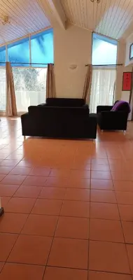 a living room with couches and a tiled floor at Mestil Guesthouse in Cape Town