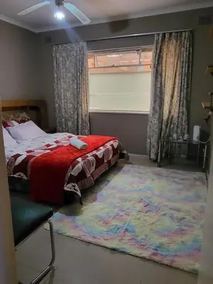 a bedroom with a bed and a large rug at Mestil Guesthouse in Cape Town
