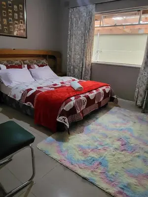 a bedroom with a bed and a large rug at Mestil Guesthouse in Cape Town