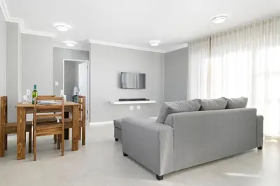 a living room with a couch and a table at Stunning, Luxurious Apartment close to the beach in Cape Town