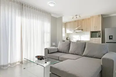 a living room with a couch and a table at Stunning, Luxurious Apartment close to the beach in Cape Town