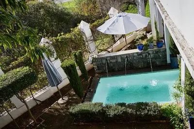 an overhead view of a swimming pool with an umbrella at Boord Guest House in Stellenbosch