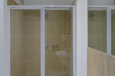 a glass shower with a sink in a bathroom at 108 Waverley in Cape Town