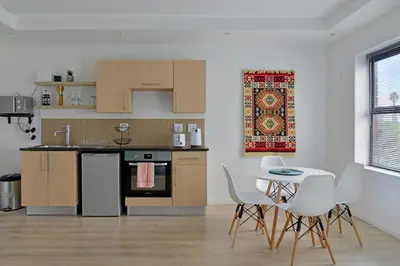 a kitchen with wooden cabinets and a table and chairs at 108 Waverley in Cape Town