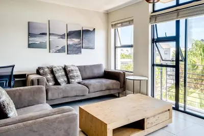 a living room with a couch and a coffee table at Quayside Canal Eden Home in Cape Town