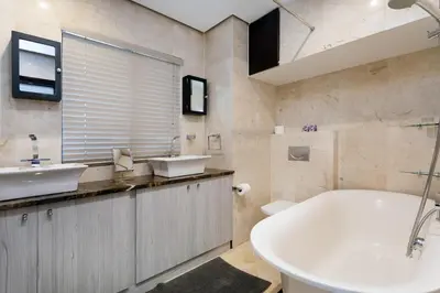 a bathroom with two sinks and a bath tub at Luxury Witsand 706 in Cape Town