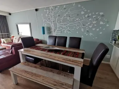 a living room with a table and two chairs at Lagoon Beach Apartment 309 in Cape Town
