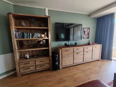 a living room with a large entertainment center with a flat screen tv at Lagoon Beach Apartment 309 in Cape Town
