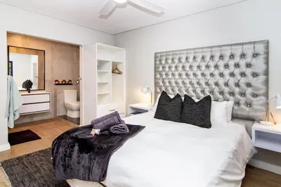a bedroom with a large bed with a large headboard at Vygeboom Villa/ Durbanville in Cape Town