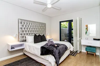 a bedroom with a large bed and a ceiling fan at Vygeboom Villa/ Durbanville in Cape Town