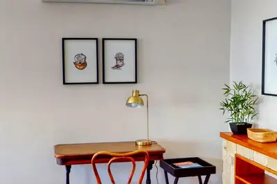 a table with a lamp and three pictures on the wall at The Links by Top Destinations Rentals in Hermanus