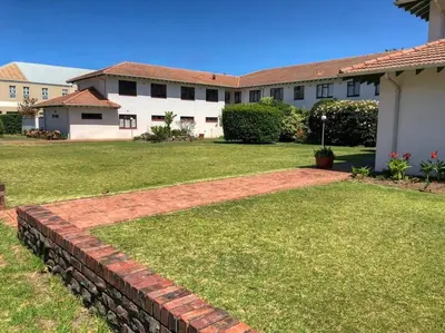 a brick retaining wall in front of a house at The Links by Top Destinations Rentals in Hermanus