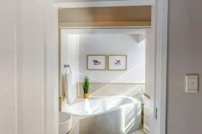 a white bathroom with a tub and a toilet at The Links by Top Destinations Rentals in Hermanus