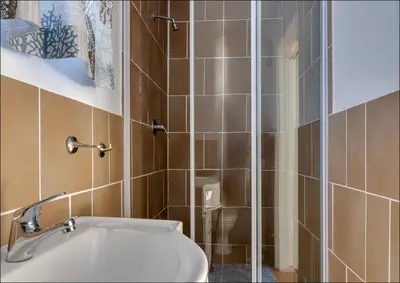 a bathroom with a toilet and a glass shower at Seaclusion in Hermanus