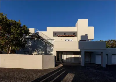 a large white building with a fence in front of it at Seaclusion in Hermanus