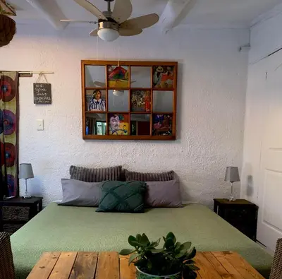 a bedroom with a green bed with a wooden table at The Farmhouse B&B in Stellenbosch