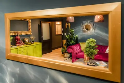 a living room with pink couches and a mirror at SW1 Lodge in Somerset West
