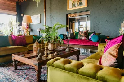 a living room with couches and a coffee table at SW1 Lodge in Somerset West