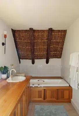 a bathroom with a bath tub and a sink at Jardin de la Ferme in Franschhoek