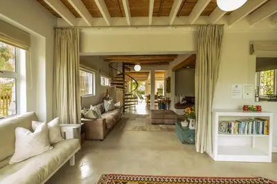 a living room with a couch and a table at Stonehaven Eco Cabins in Hermanus