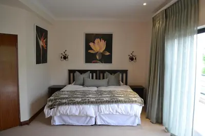 a bedroom with a large bed and a window at Pearl Valley-Golf Safari SA in Paarl