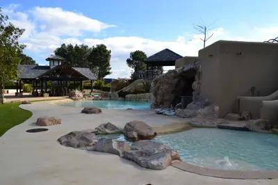 a swimming pool in a backyard with rocks in the water at Pearl Valley-Golf Safari SA in Paarl