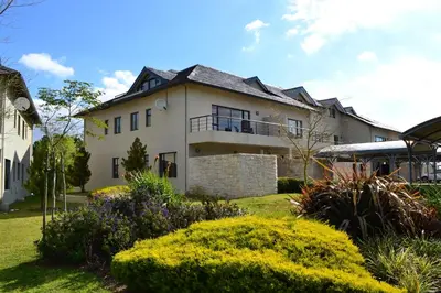 a large white house with bushes in front of it at Pearl Valley-Golf Safari SA in Paarl