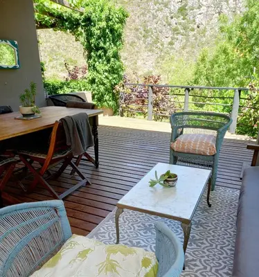 a patio with two chairs and a table and a tableablish at Porcupine Hills Olive and Guest Farm in Botrivier
