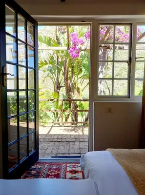 a bedroom with a bed and a door to a garden at Porcupine Hills Olive and Guest Farm in Botrivier