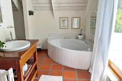 a white bathroom with a tub and a sink at Lagoon View in Hermanus in Hermanus