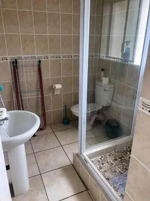 a bathroom with a shower and a toilet and a sink at Hermanus Beach Club 31 in Hermanus
