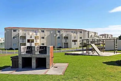 a park with a playground in front of a building at Hermanus Beach Club 31 in Hermanus