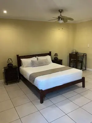 a bedroom with a large bed and two night stands at Classic Cape Dutch Studio Apartment in Cape Town