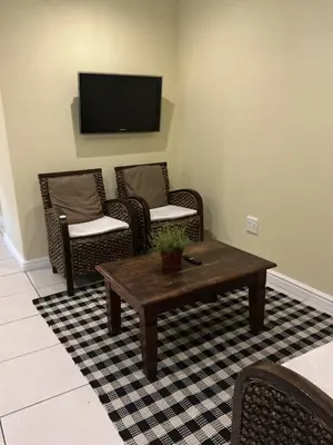 a living room with a table and chairs and a television at Classic Cape Dutch Studio Apartment in Cape Town