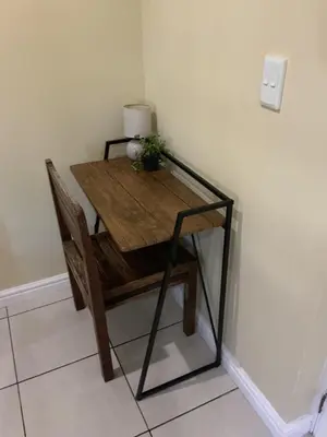 a wooden table in a corner with a plant on it at Classic Cape Dutch Studio Apartment in Cape Town