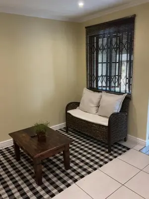 a living room with a couch and a coffee table at Classic Cape Dutch Studio Apartment in Cape Town